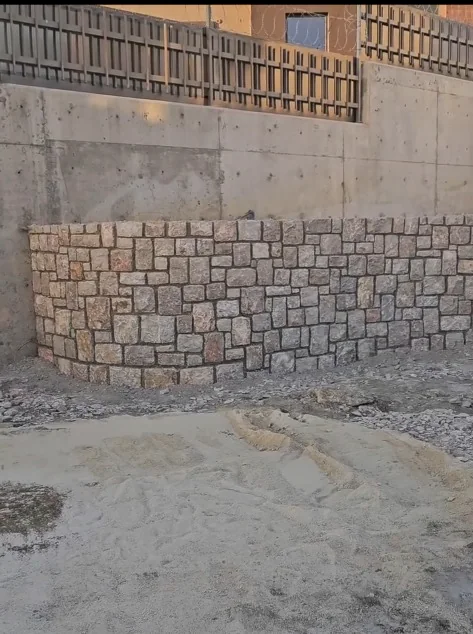 Beton temel üzerine inşa edilmiş kavisli doğal taş duvar