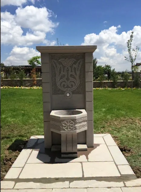 Bahçede yer alan oyma desenli doğal taş çeşme